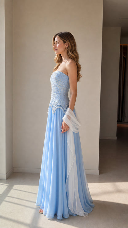 Side profile view of light blue beaded corset maxi dress with flowing skirt
