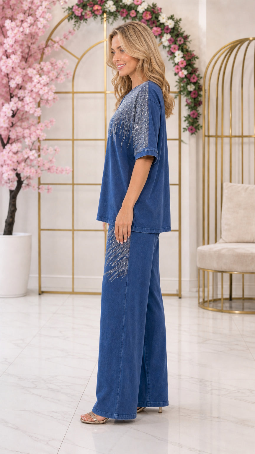 Side profile view of woman wearing denim blue two-piece embellished pant set