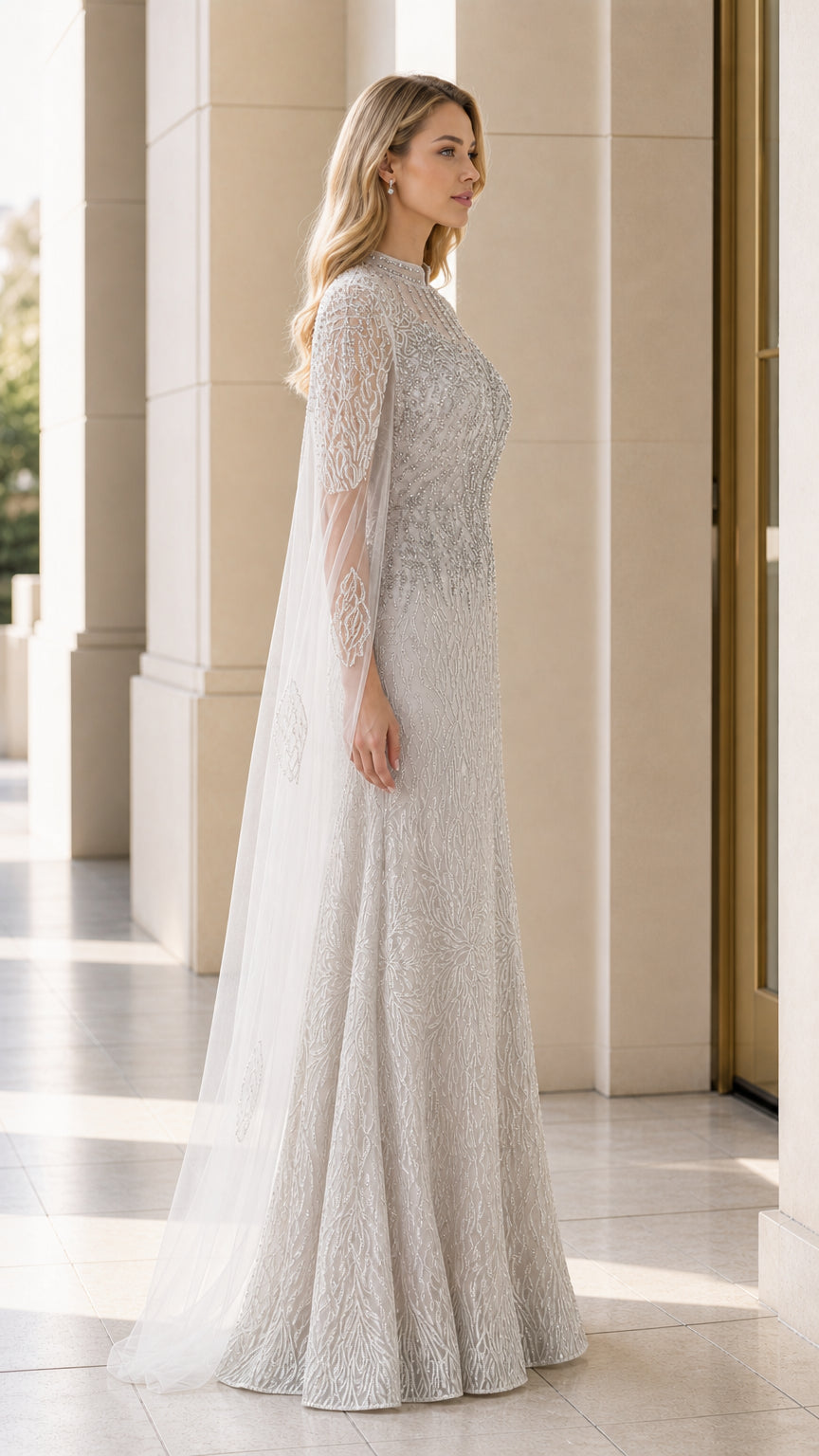 Side profile of silver beaded cape formal dress showing floor-length drape