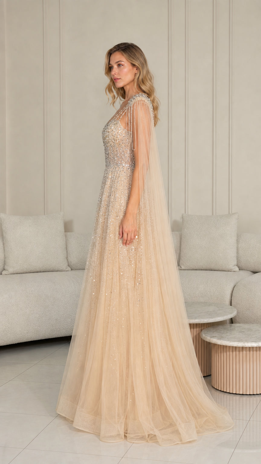 Side profile of champagne tulle formal dress with beaded shoulder cape