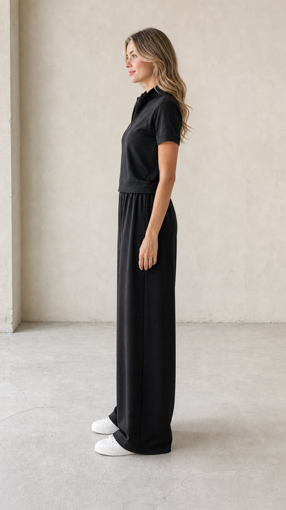 Side profile view of woman wearing black two-piece wide-leg lounge set