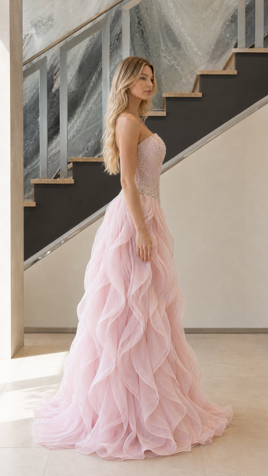 Side profile of woman wearing blush pink strapless ruffle evening dress