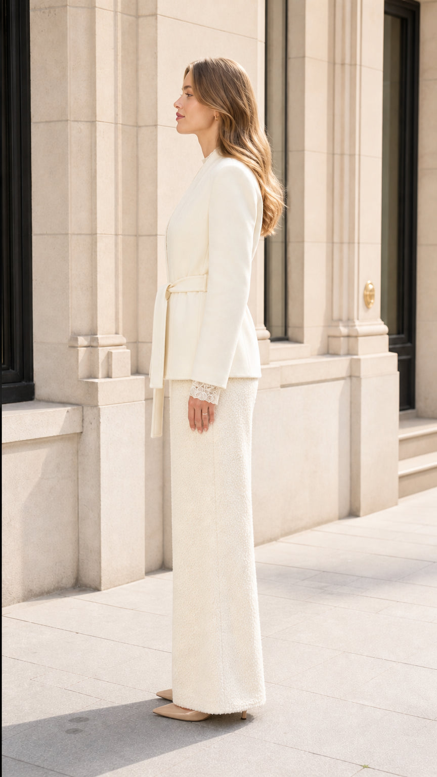 Side profile view of model wearing Cream tailored suit set with tie belt