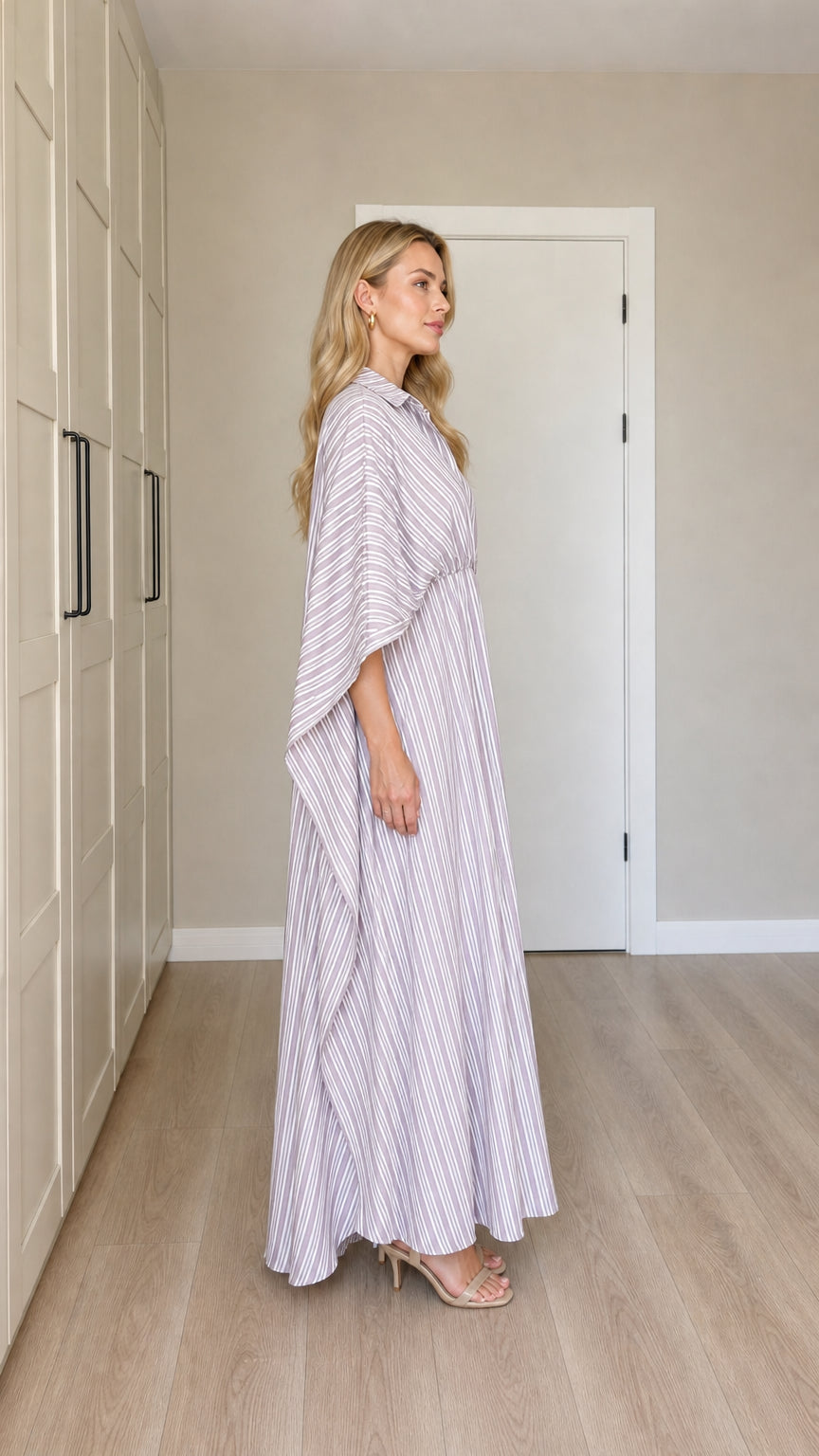 Side profile of woman in flowing lavender striped cape maxi dress
