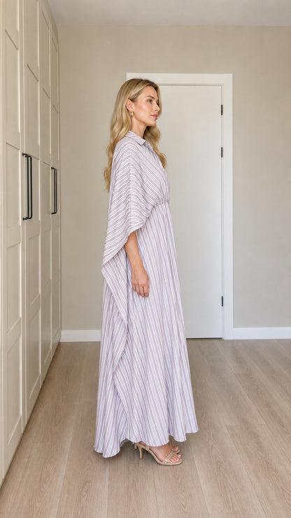 Side profile of woman in flowing lavender striped cape maxi dress