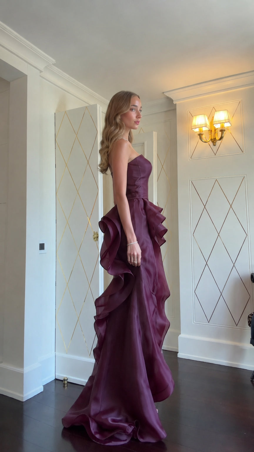 Side view of model in Burgundy strapless maxi dress showing side ruffles