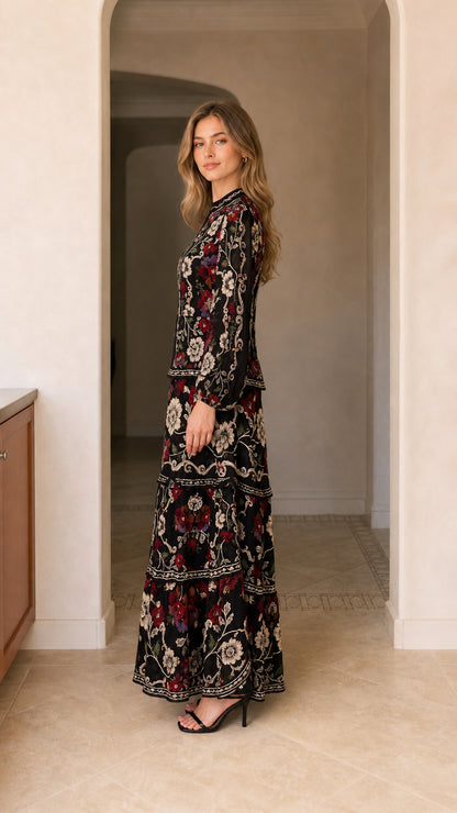 Side angle view of model wearing black long sleeve floral tiered maxi dress