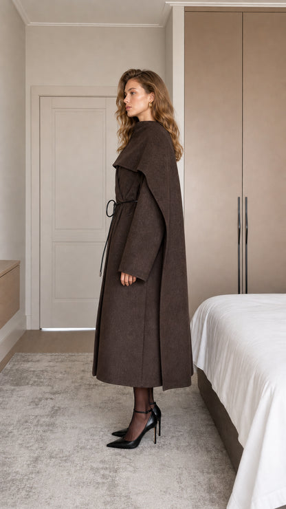 Side profile view of chocolate brown maxi cape coat showing sleeve and drape