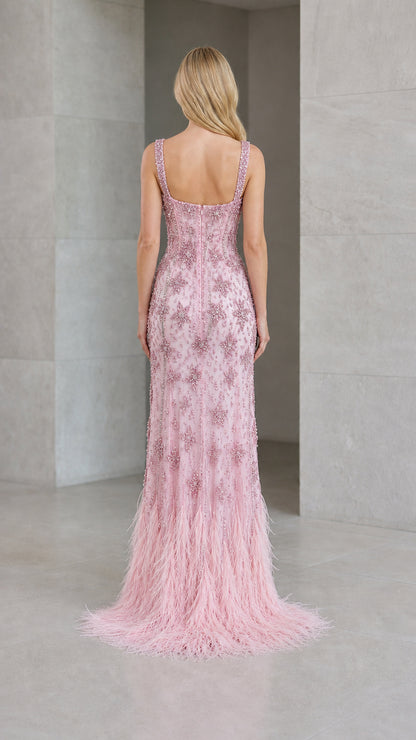 Back view of model in blush pink beaded evening gown showing open scoop back and train