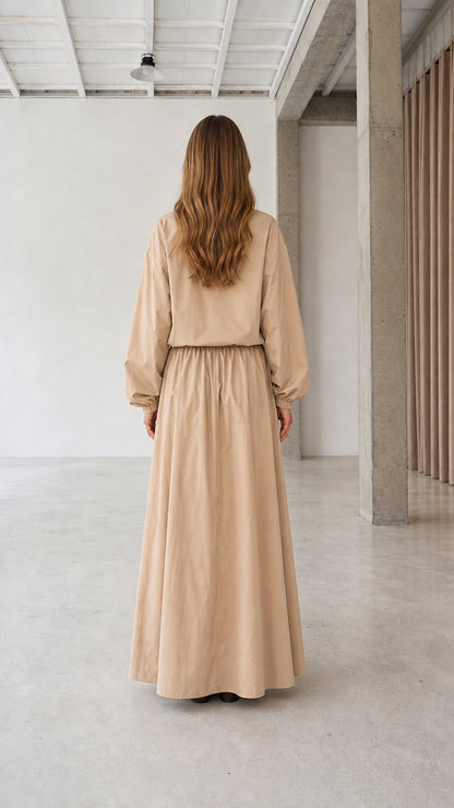 Back view of woman wearing beige modest long sleeve maxi dress