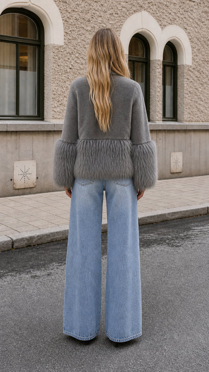Model wearing grey faux fur jacket with fluffy cuffs, back view