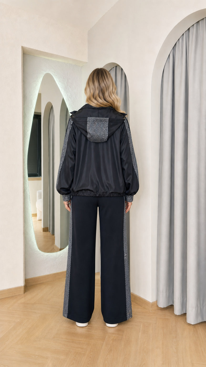Back view of model wearing the black hooded tracksuit set highlighting the sequin hood panel and relaxed pant silhouette