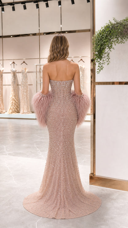 Back view of Blush Pink strapless gown with floor-sweeping train and feather cuff sleeves