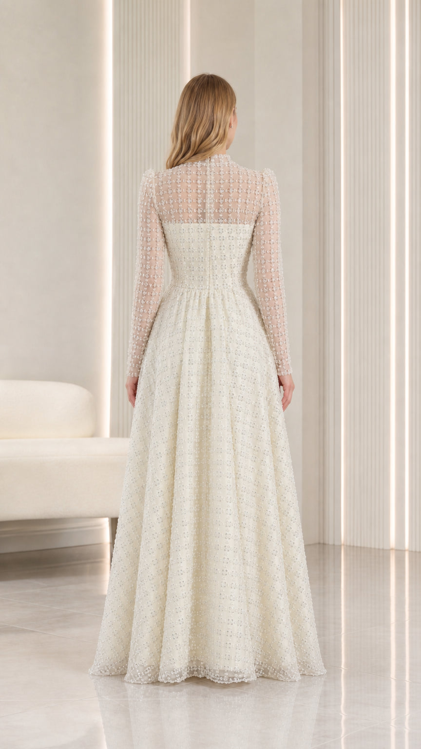 Back view of model in ivory illusion high-neck evening gown with long sleeves