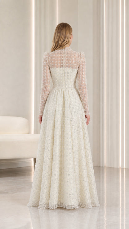 Back view of model in ivory illusion high-neck evening gown with long sleeves