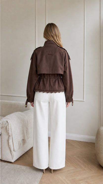 Back view of brown cropped jacket showing storm flap and scalloped lace hem