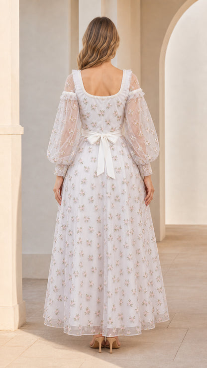 Back view of model showing tie-back sash on white embroidered evening dress