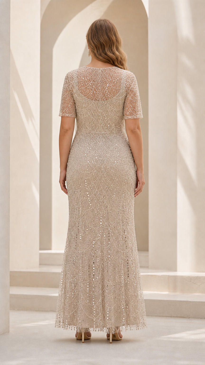 Back view of woman in Champagne sequin and pearl beaded evening gown