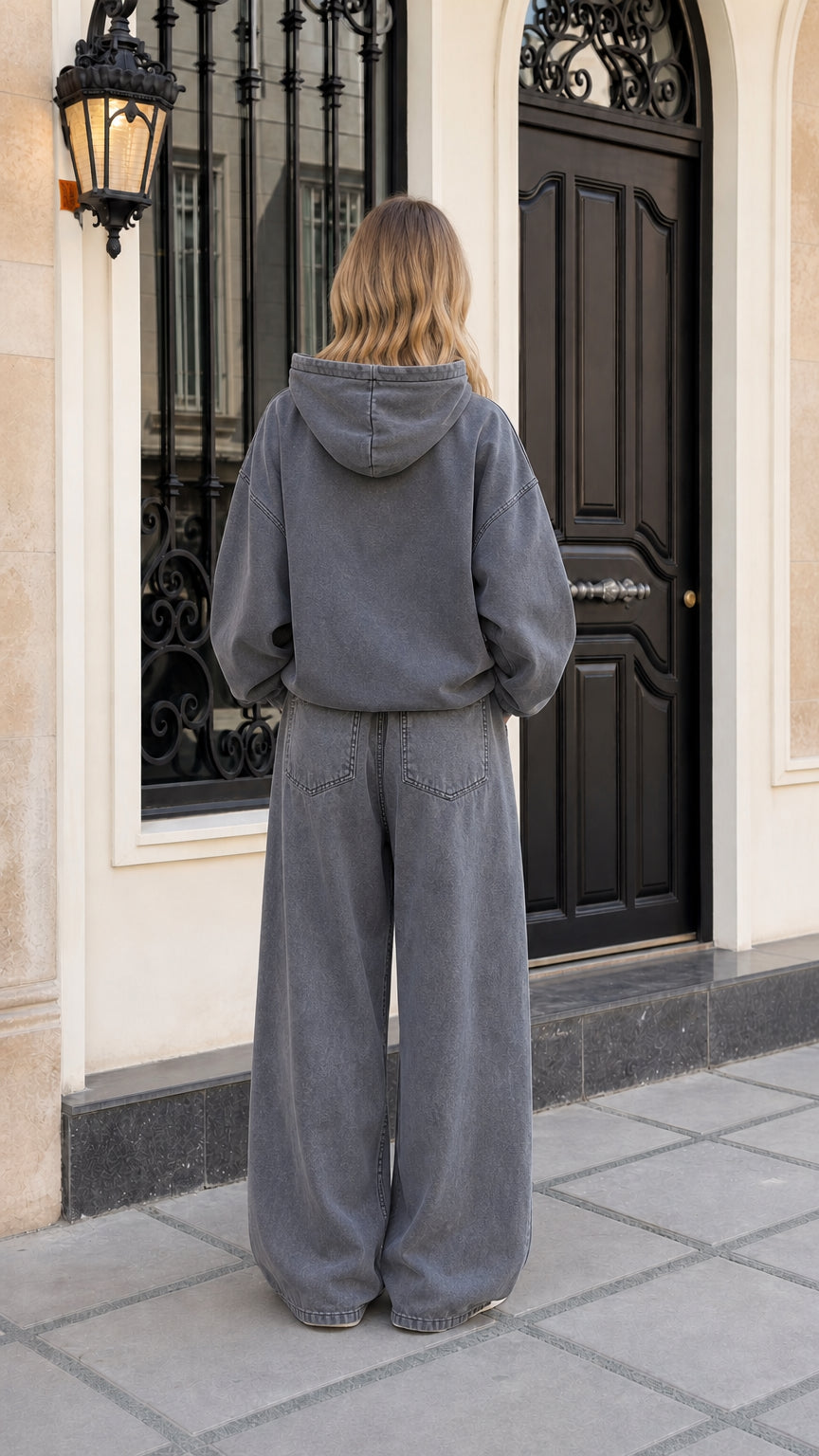 Back view of woman wearing washed charcoal fleece hoodie and wide-leg tracksuit