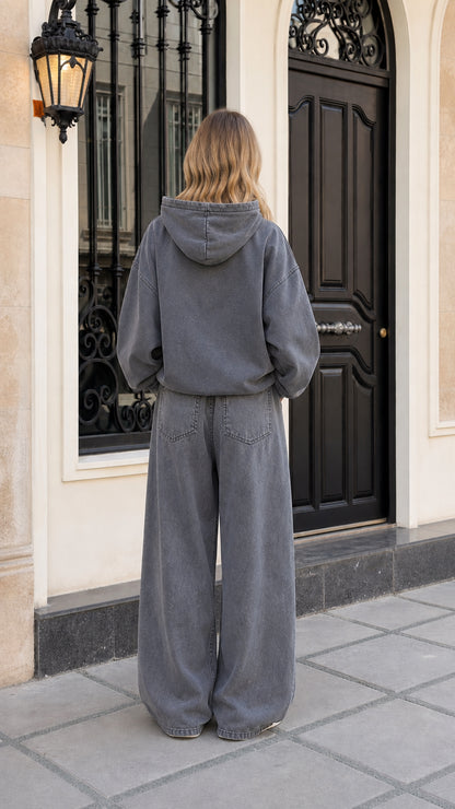 Back view of woman wearing washed charcoal fleece hoodie and wide-leg tracksuit