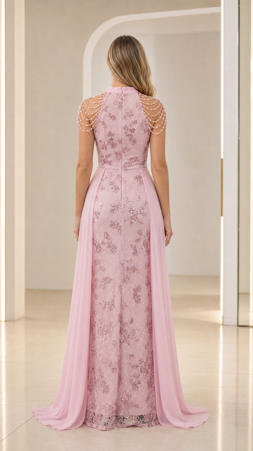 Back view of pink high neck embroidered lace gown with chiffon cape overskirt