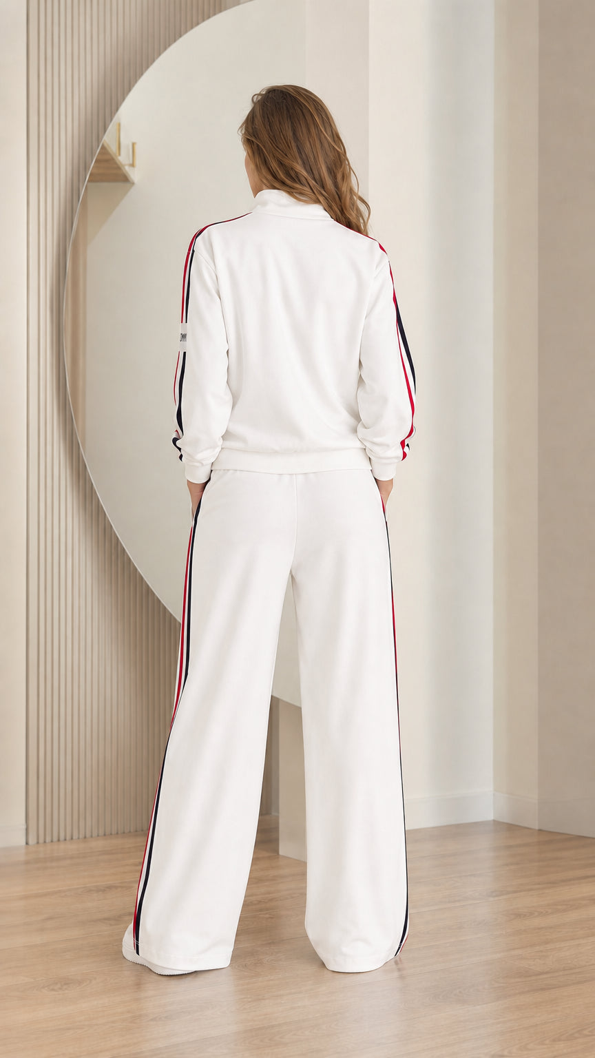 Back view of model wearing white zip-up jacket and wide-leg track pants