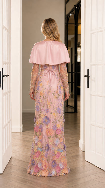 Back view of blush pink capelet formal gown showing floor-length embroidered skirt