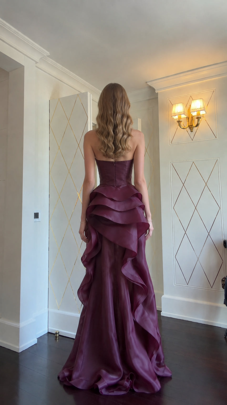 Back view of model in Burgundy strapless tiered ruffle formal gown
