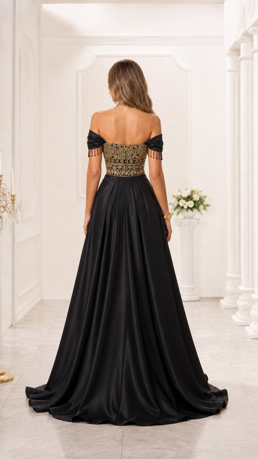 Back view of model in black formal satin gown showing off-shoulder cut and floor-length skirt