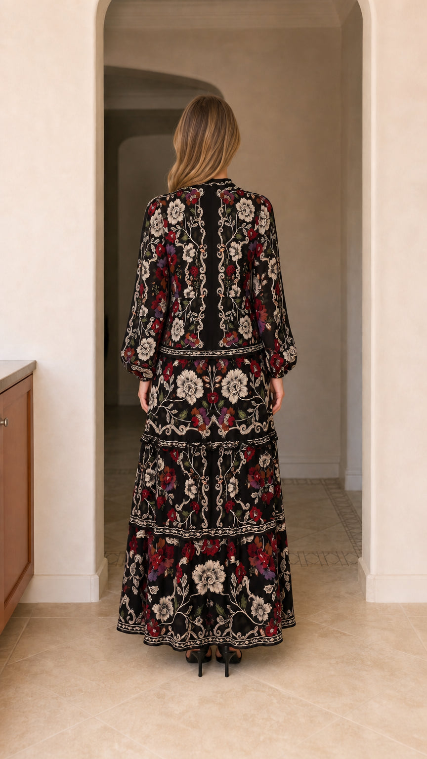 Back view of model showing tiered skirt and back bodice of black floral maxi dress