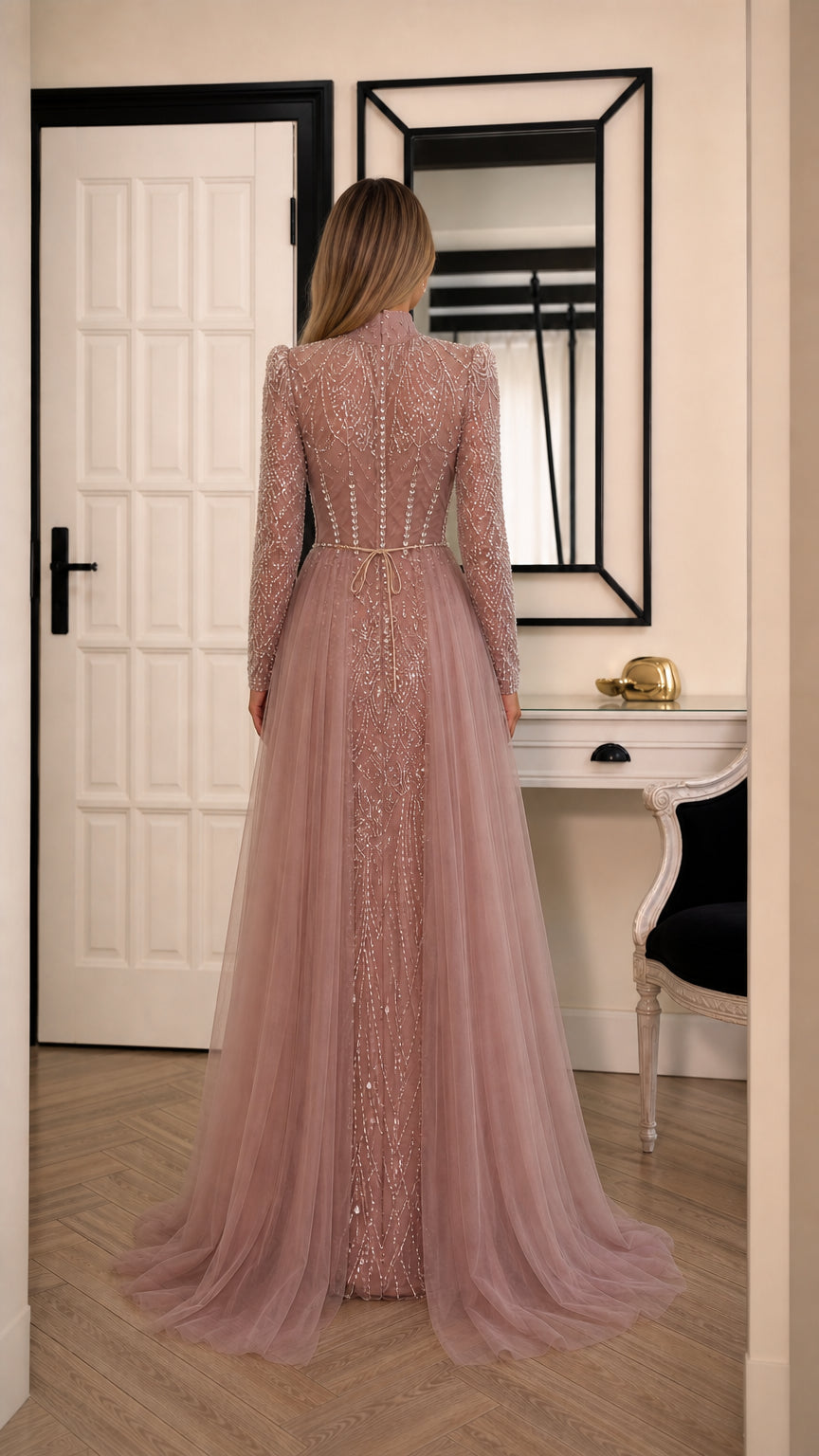 Back view of model in dusty rose beaded evening dress showing flowing tulle skirt