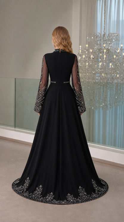 Back view of the black evening gown showcasing sheer mesh upper and detailed hemline