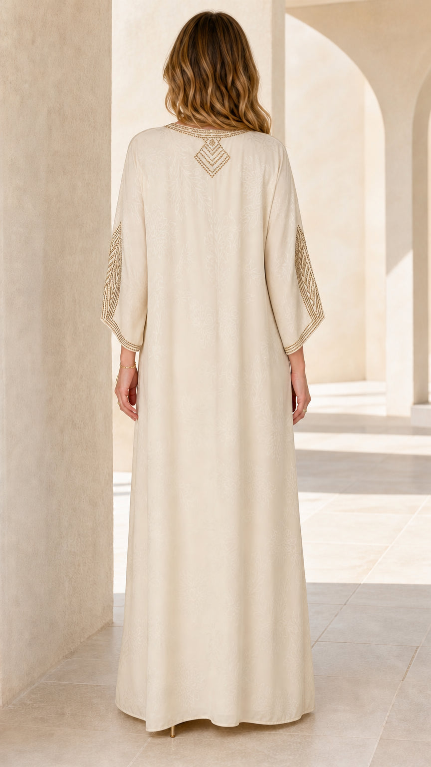 Back view of model wearing Cream kaftan dress with upper-back rhinestone embellishment