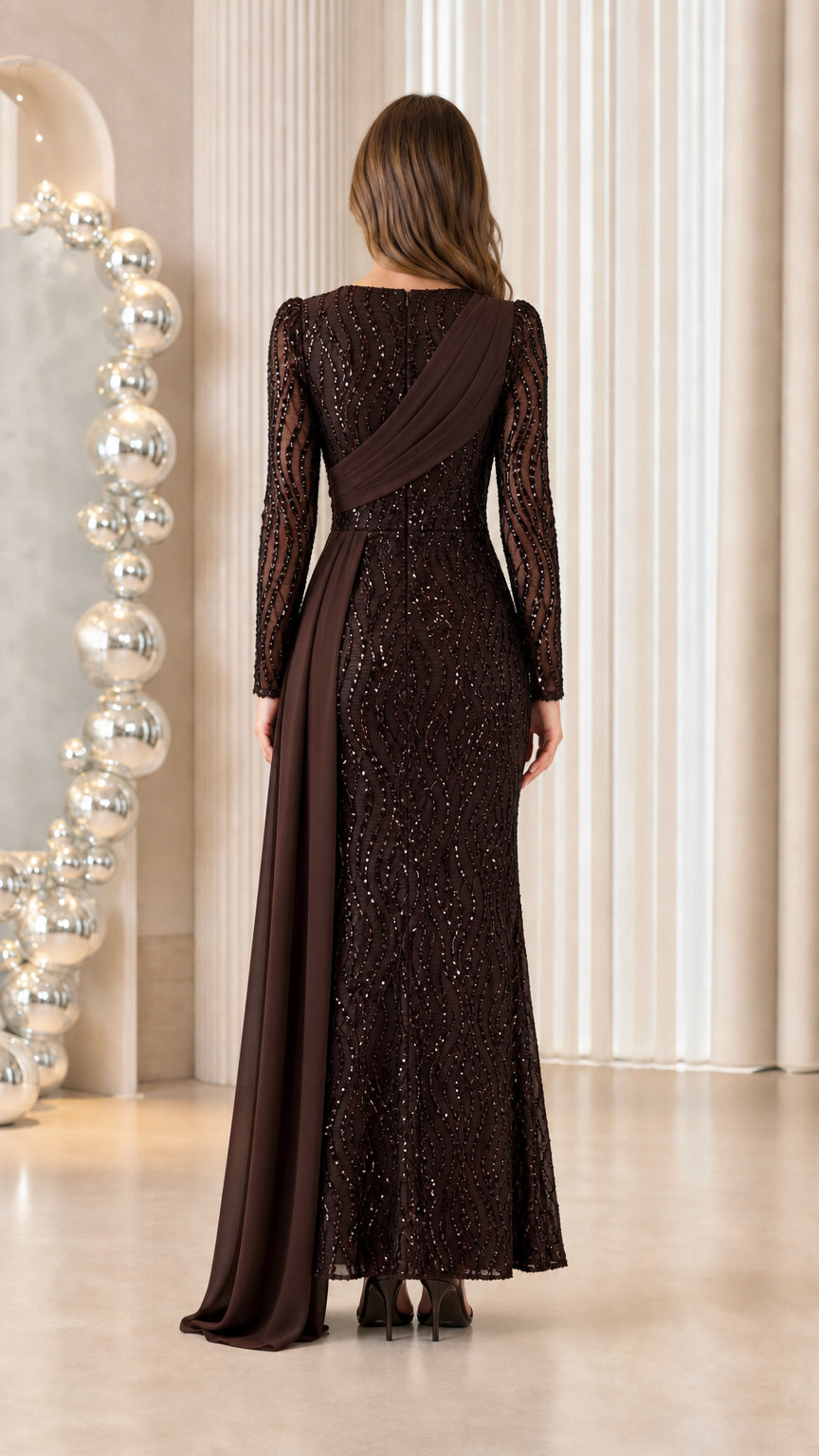 Back view of woman wearing chocolate brown long sleeve sequined maxi dress with draped shoulder detail