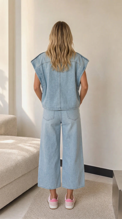 Back view of model showing relaxed fit and back yoke seam of Light Blue denim vest