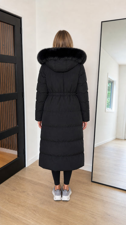 Back view of black long puffer parka showing quilted panels and cinched waist