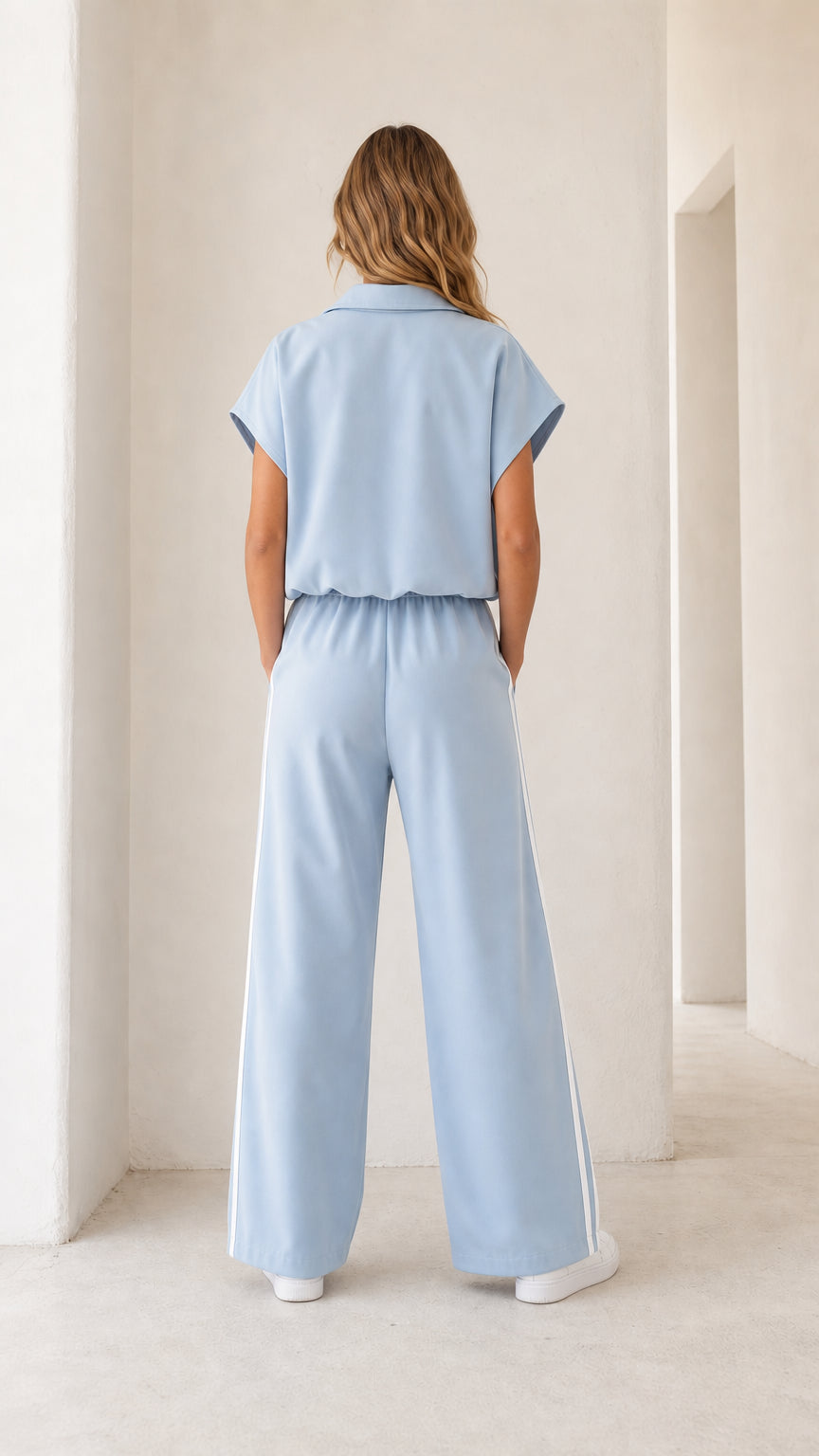 Back view of light blue short sleeve wide leg jumpsuit with elastic waistband