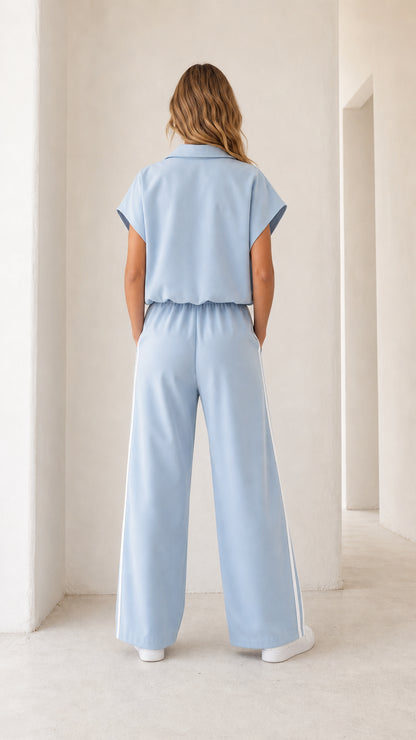 Back view of light blue short sleeve wide leg jumpsuit with elastic waistband