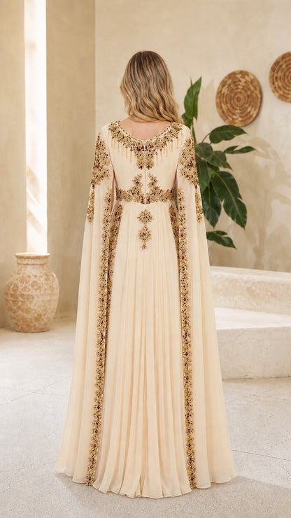 Back view of model showcasing long draped cape on champagne evening gown