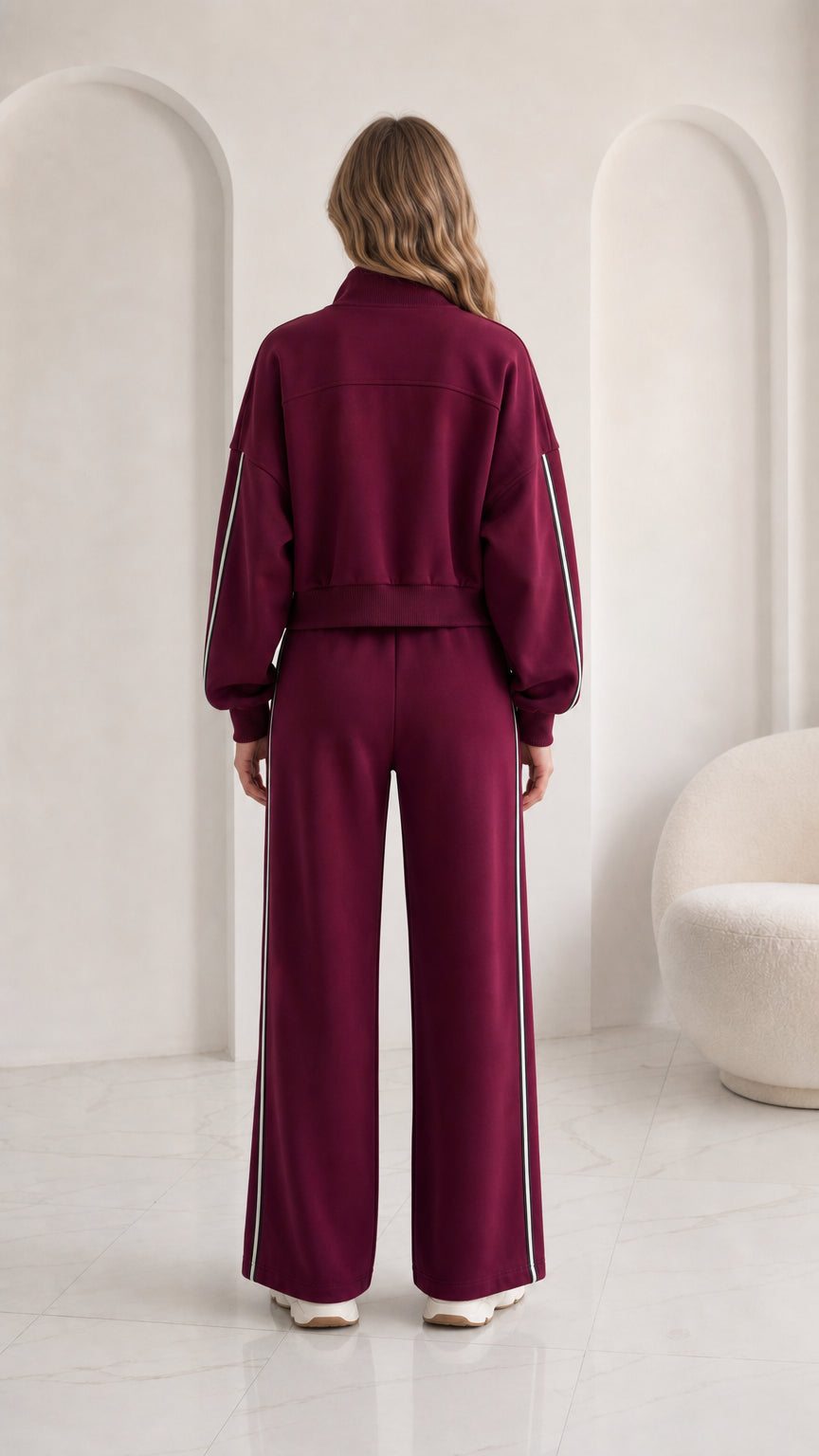 Back view of woman wearing burgundy full-zip jacket and track pants set