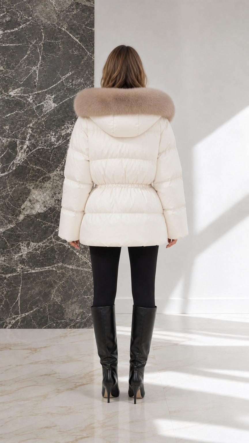 Back view of model in off-white mid-length quilted winter coat with fur trimmed hood