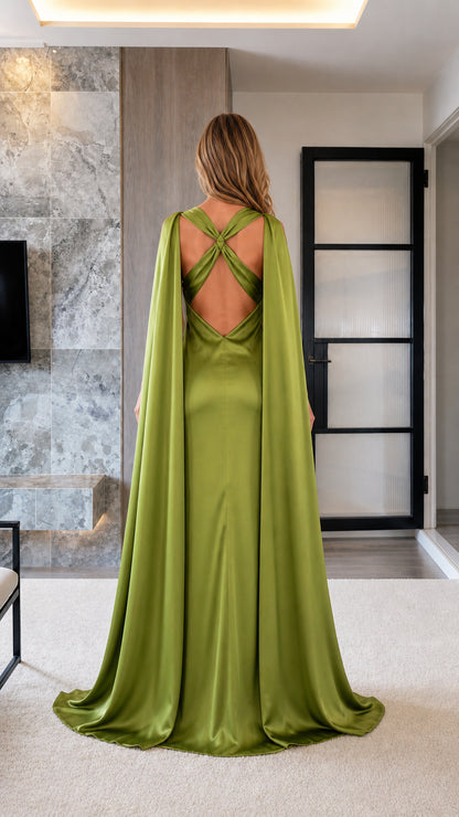 Back view showing criss-cross straps and flowing cape on olive green satin gown