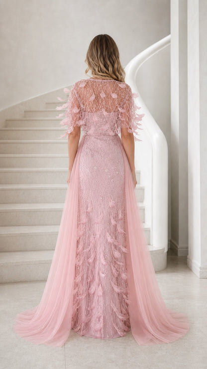 Back view of blush pink embroidered gown with sheer illusion back and flowing train