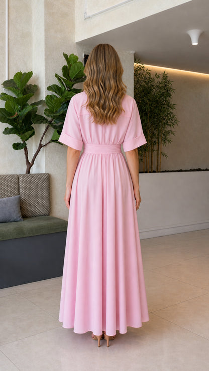 Back view of woman wearing blush pink flowing pleated maxi dress
