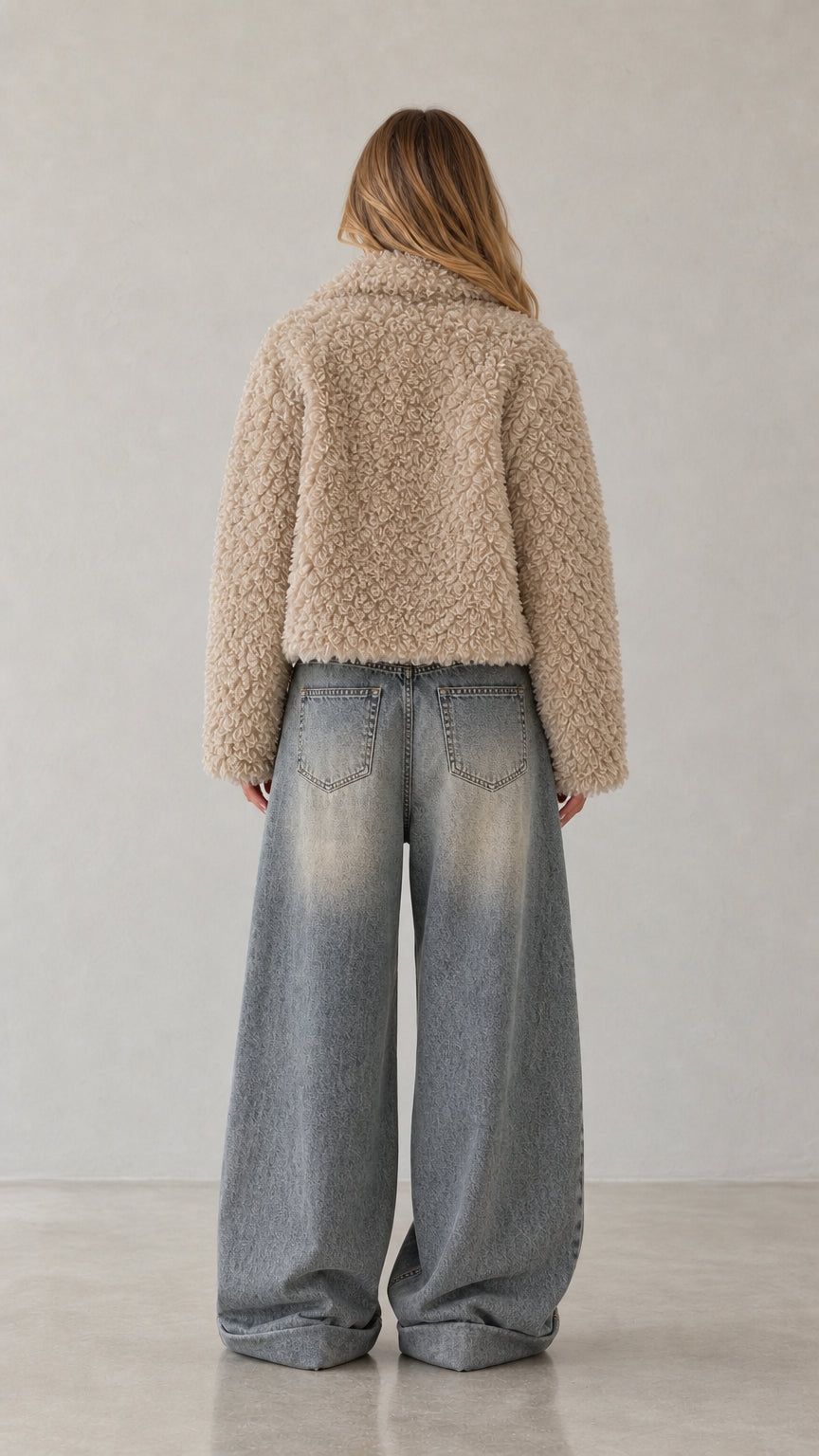 Back view of woman wearing beige cropped teddy fleece jacket