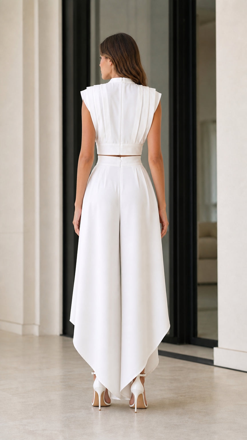 Back view of model wearing white sleeveless crop top and flowing wide-leg pants set