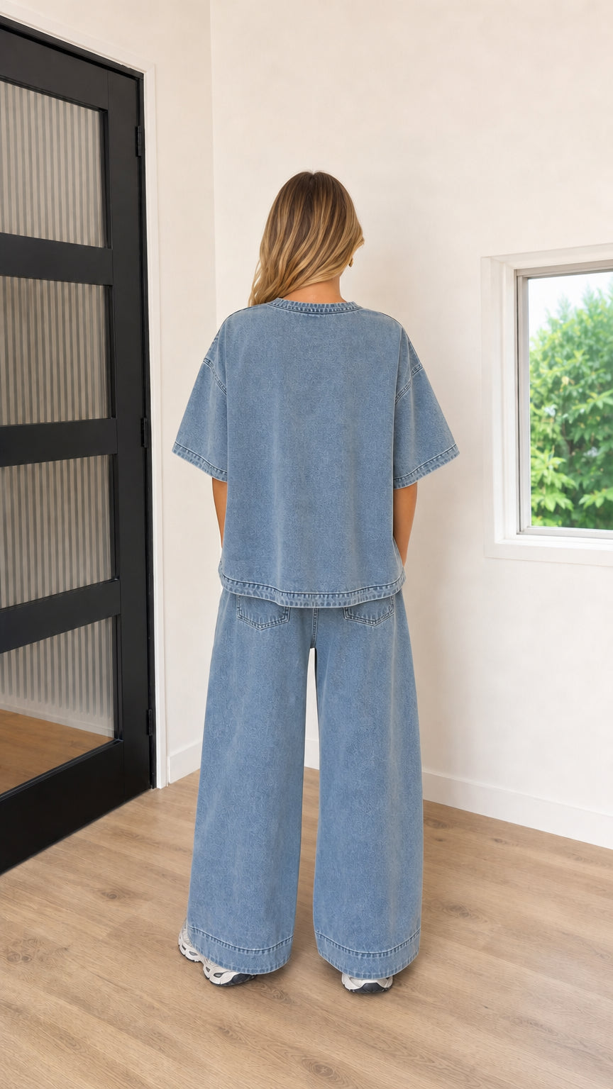 Back view of model wearing Washed Blue oversized drop-shoulder tee and wide-leg trousers