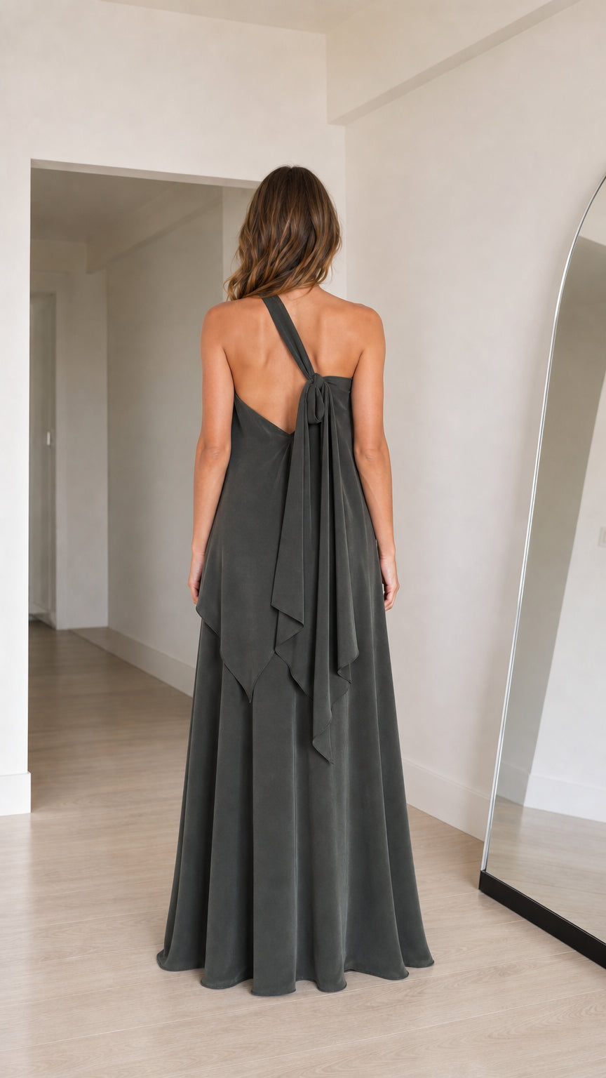 Back view of charcoal grey one-shoulder maxi dress showcasing tied shoulder drape
