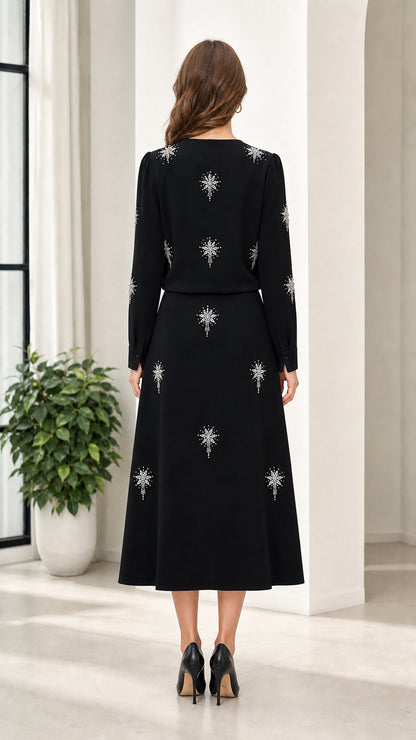 Back view of woman wearing black long sleeve rhinestone embellished midi dress