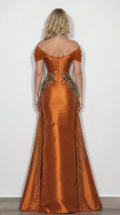 Back view of rust orange satin gown featuring off-the-shoulder straps and flared overskirt
